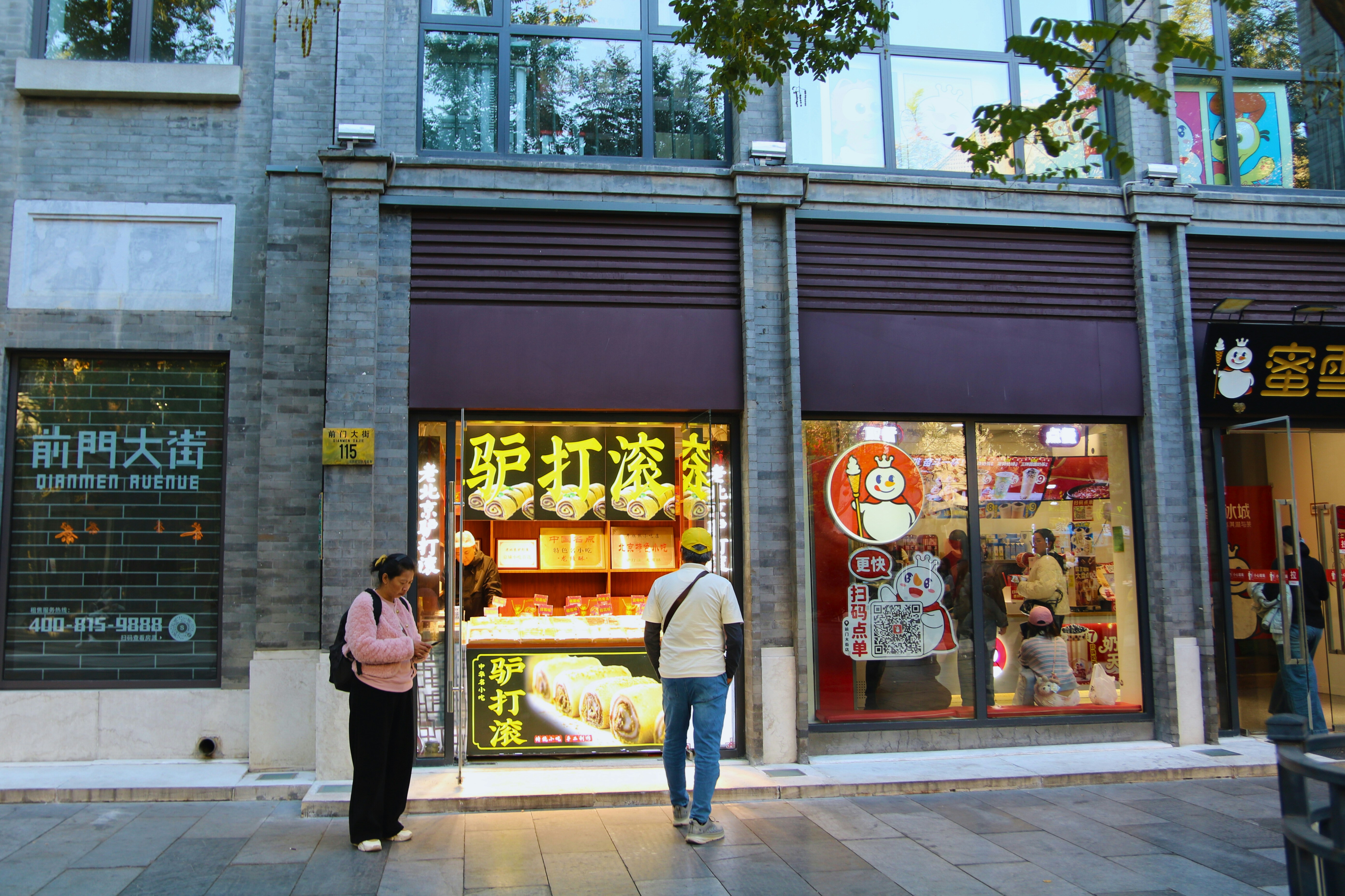 People outside a shop with illuminated signs